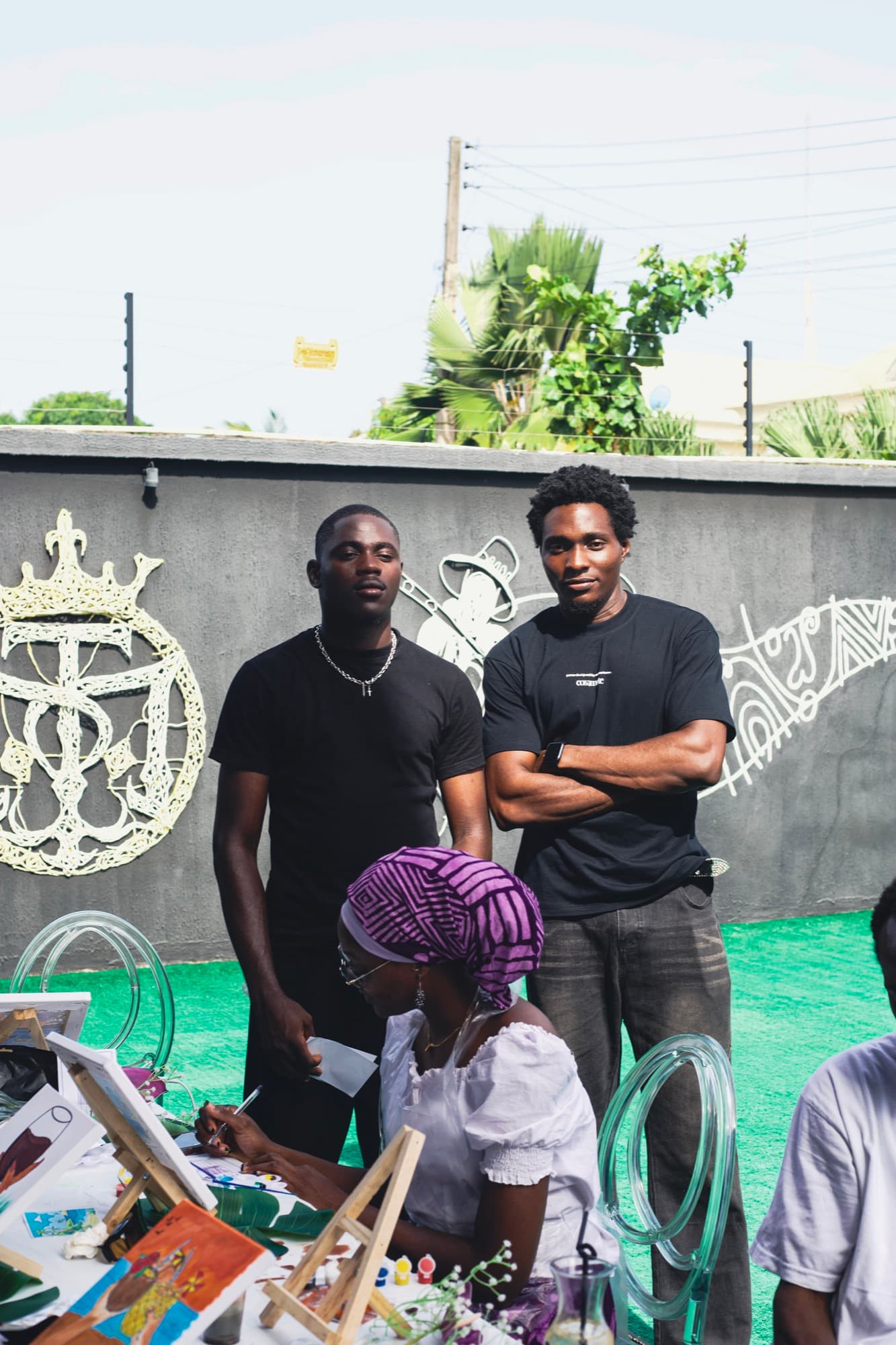 Guests at the Sip & Paint session in front of the Ogidi Studio mural.