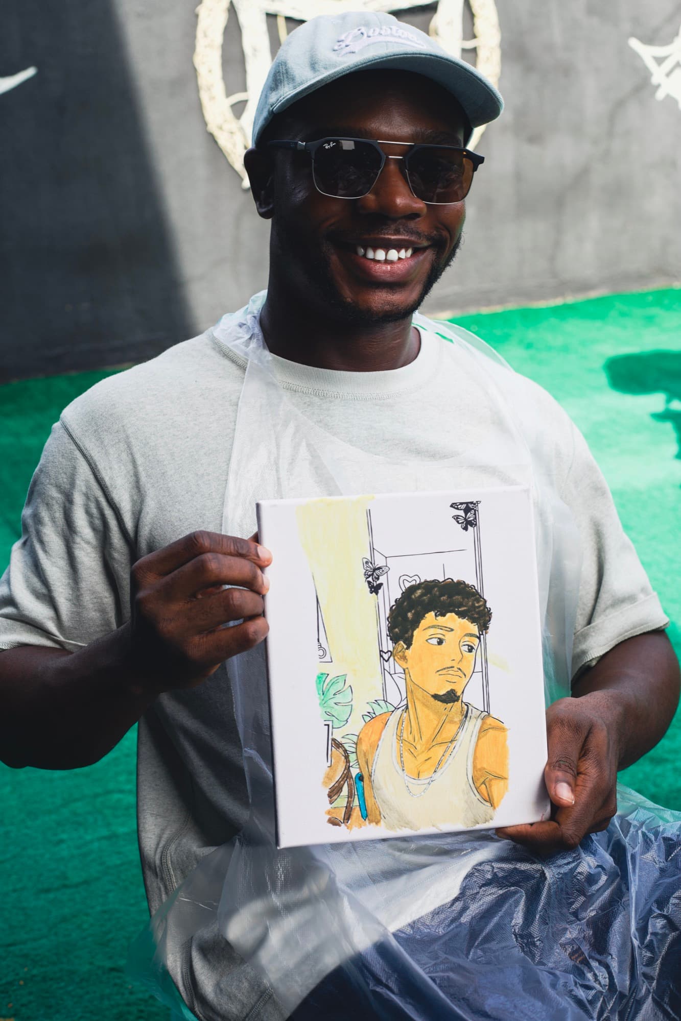 A guest holding up their finished painting at the Sip & Paint session.