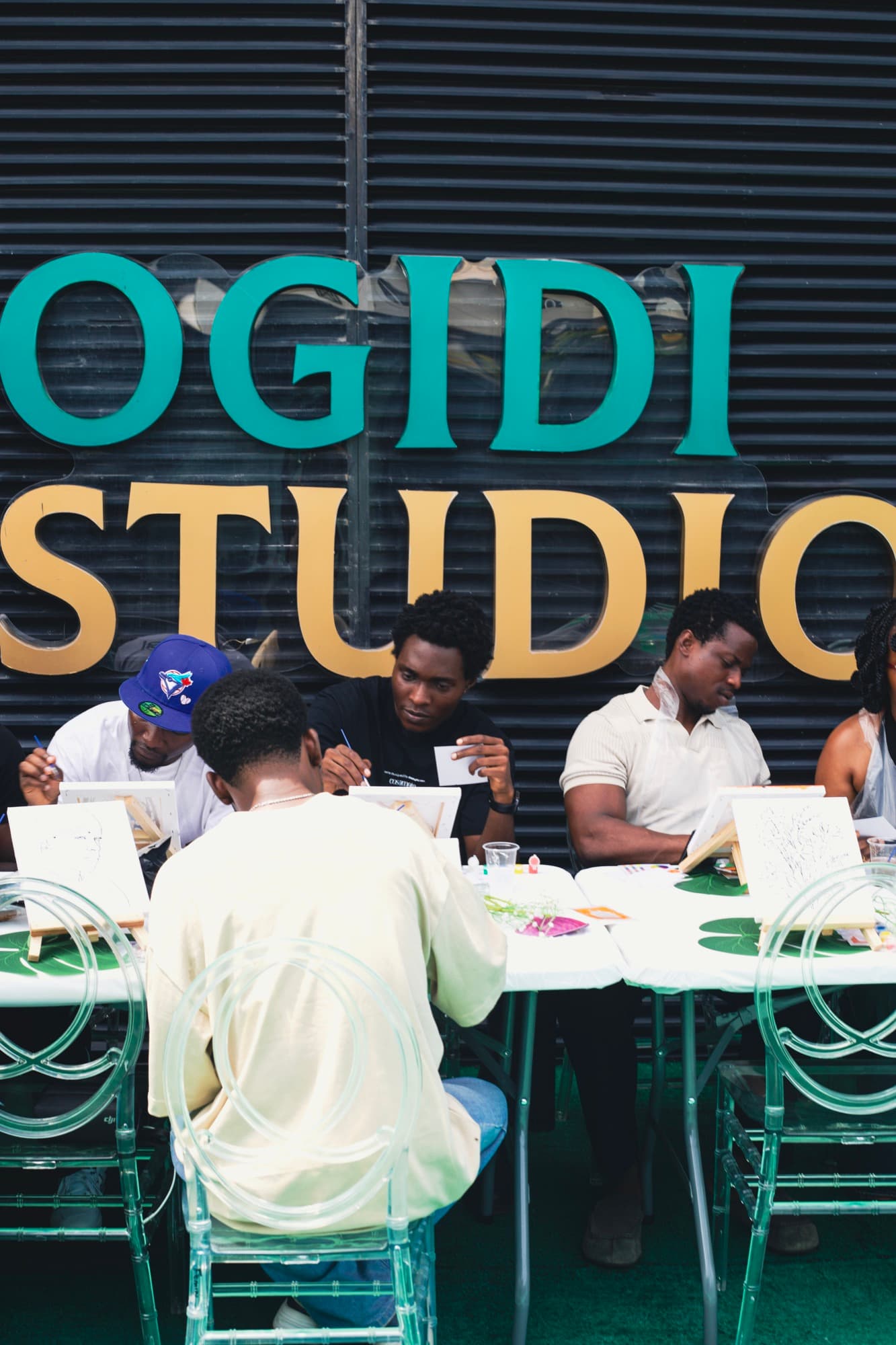 Guests painting in front of the Ogidi Studio signage.