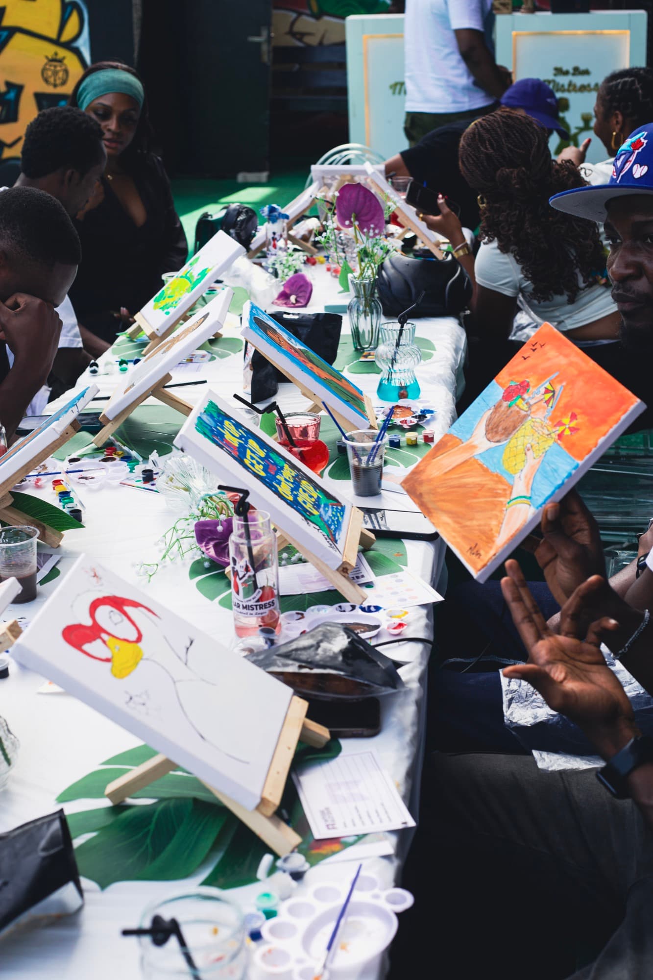 Guests painting together at a shared table at the Sip & Paint session.